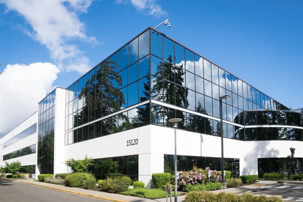 Office building with a glass curtain wall under a blue sky